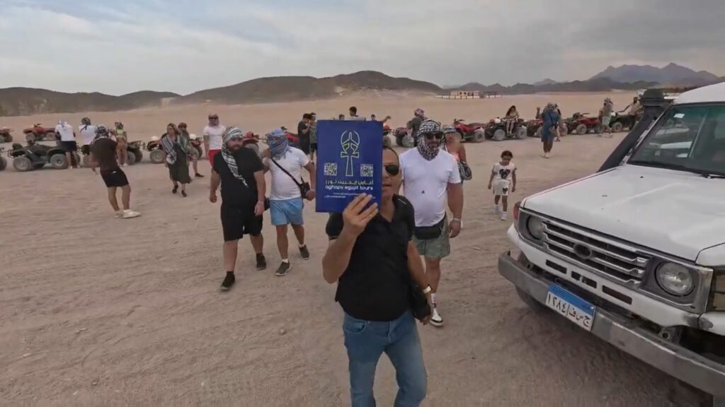 Guide Aghapy avec la pancarte de l'agence pendant un safari en jeep à Hurghada